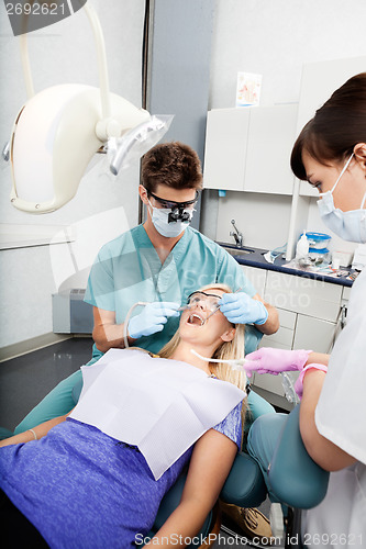 Image of Dentist And Female Assistant Treating A Patient At Clinic