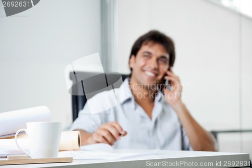 Image of Coffee Cup On Desk With Blueprints