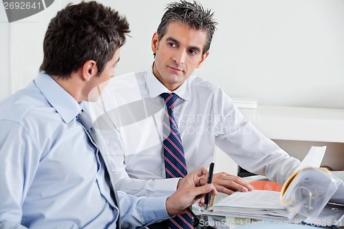 Image of Businessmen Discussing Paperwork In Office