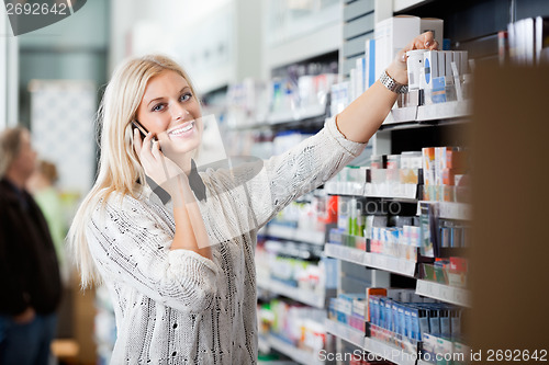 Image of Young Woman Using Mobile Phone In Pharmacy