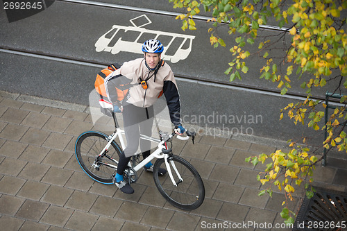 Image of Young Male Cyclist With Backpack On Sidewalk