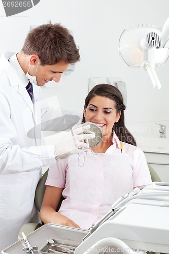 Image of Dentist Showing Result Of His Work To Patient
