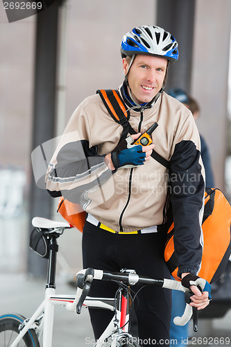 Image of Male Cyclist With Courier Bag Using Walkie-Talkie