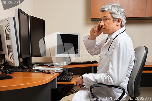 Image of Doctor Attending Phone Call At Clinic