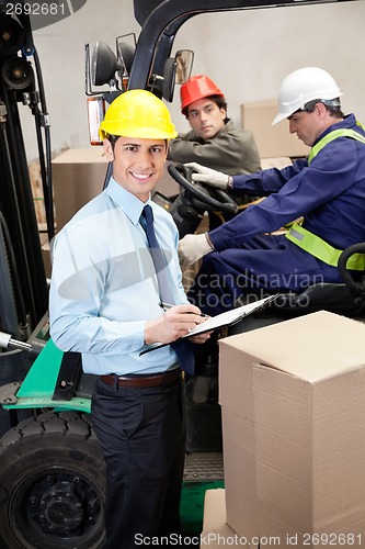 Image of Supervisor With Foremen Working At Warehouse