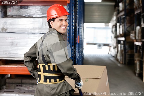 Image of Warehouse Worker Pushing Handtruck With Cardboard Boxes