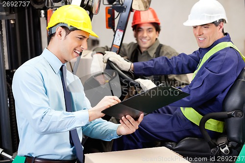 Image of Male Supervisor Communicating With Forklift Driver And Foreman