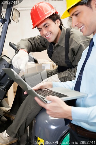 Image of Supervisor And Forklift Driver Using Laptop