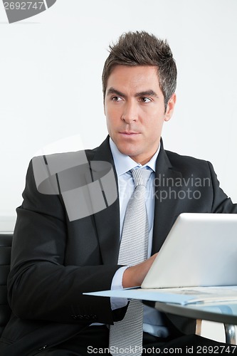 Image of Young Businessman Using Digital Tablet In Office