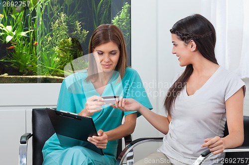 Image of Woman Paying Through Credit Card To Dentist