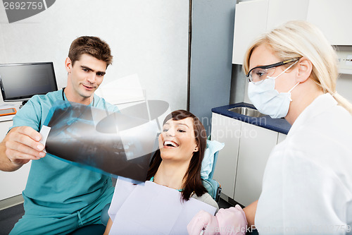 Image of Dentist With Female Assistant Showing X-Ray Image To Patient