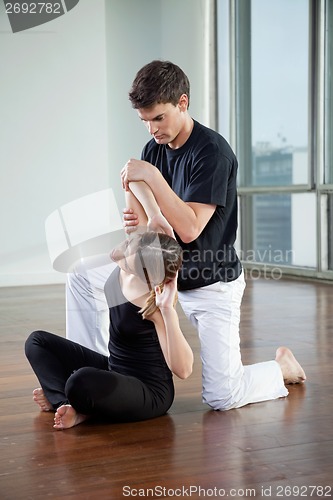 Image of Instructor Helping Woman In Yoga Exercise