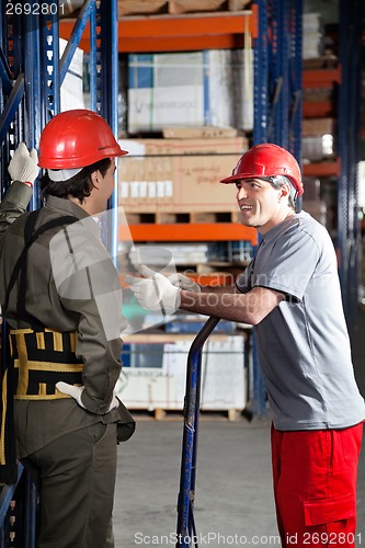 Image of Foreman Communicating With Coworker At Warehouse