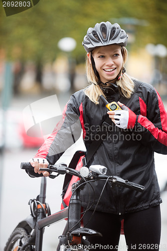 Image of Female Cyclist With Courier Bag Using Walkie-Talkie