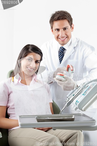 Image of Dentist And Patient With Teeth Model In Clinic