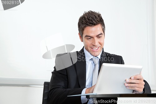 Image of Young Businessman Using Digital Tablet In Office