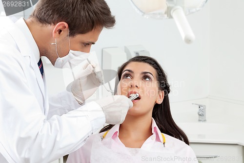 Image of Dentist Examining Patient's Mouth