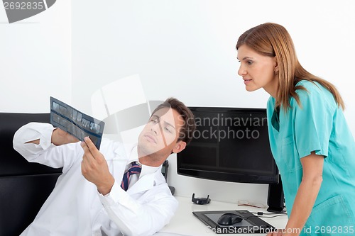 Image of Dentist Analyzing X-Ray With Assistant