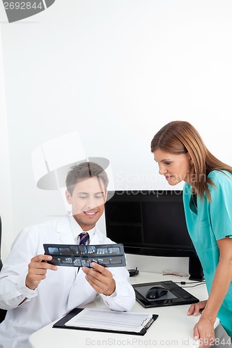 Image of Dentist Analyzing X-Ray With Assistant