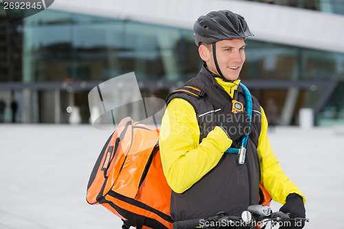 Image of Male Cyclist With Courier Delivery Bag Using Walkie-Talkie