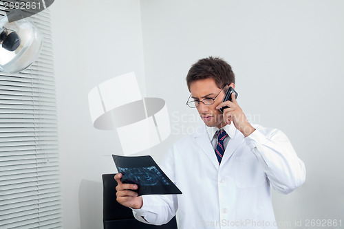 Image of Male Dentist With X-Ray Using Mobile Phone