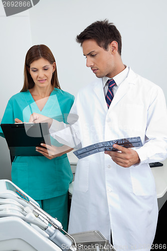 Image of Doctor And Assistant Analyzing Patient's Report