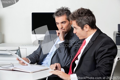 Image of Thoughtful Businessmen Using Digital Tablet At Desk