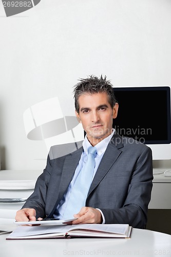 Image of Businessman With Digital Tablet Sitting At Desk