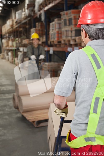 Image of Warehouse Workers Pushing Handtruck