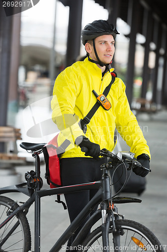 Image of Young Man With Bicycle And Bag Looking Away