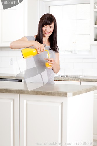 Image of Pregnant Woman pouring Orange Juice