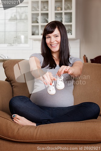 Image of Pregnant Woman with Baby Shoes