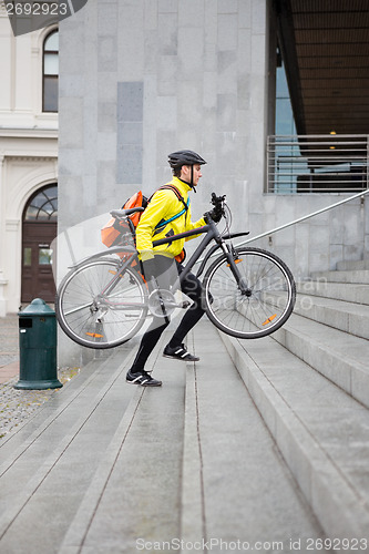 Image of Courier Delivery Man With Bicycle And Backpack Walking Up Steps