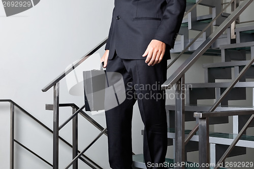 Image of Low Section Of Businessman Walking Down The Stairs