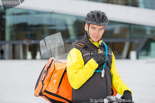 Image of Cyclist With Courier Delivery Bag Using Walkie- Talkie