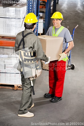 Image of Foremen Carrying Cardboard Box At Warehouse