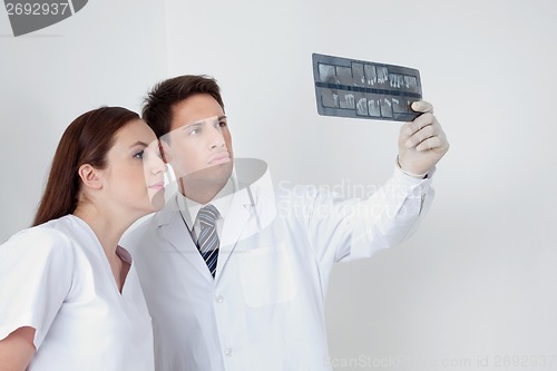 Image of Doctor And Assistant Analyzing Patient's Report