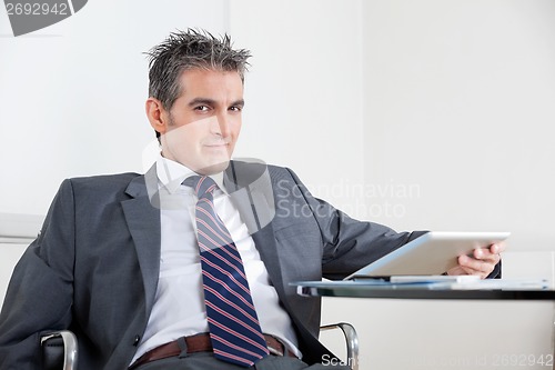 Image of Businessman Using Digital Tablet In Office