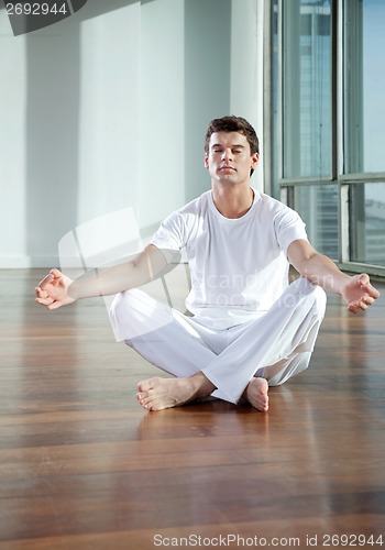 Image of Young Man Meditating At Gym