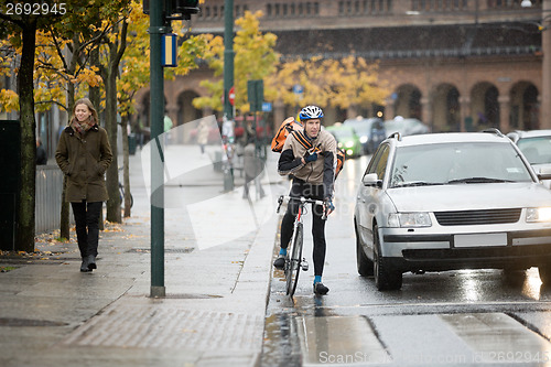 Image of Male Cyclist Using Walkie-Talkie On Street