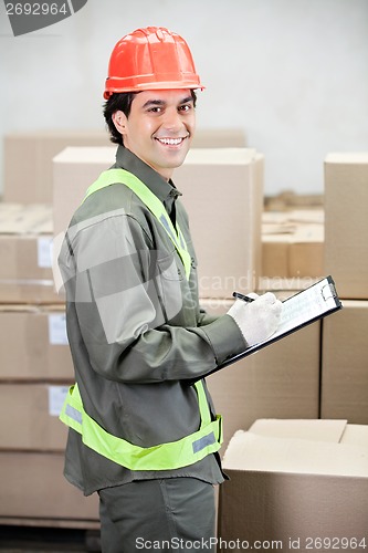 Image of Supervisor Writing Notes At Warehouse