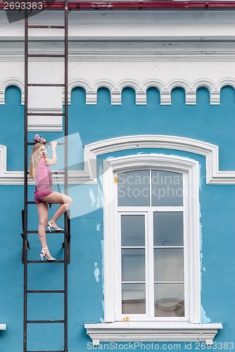 Image of Pretty woman on fire escape stair