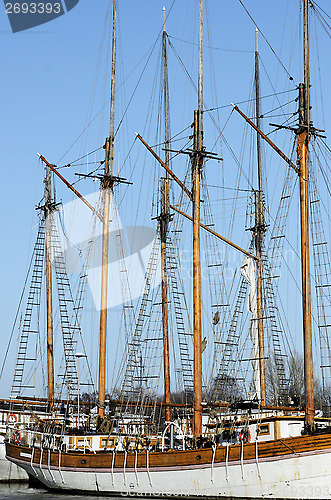 Image of wooden sailboat mast on blue sky
