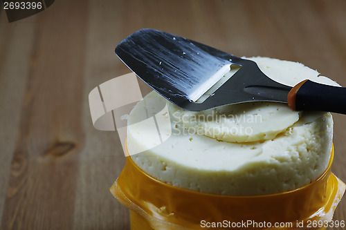 Image of head cheese and knife on a wooden