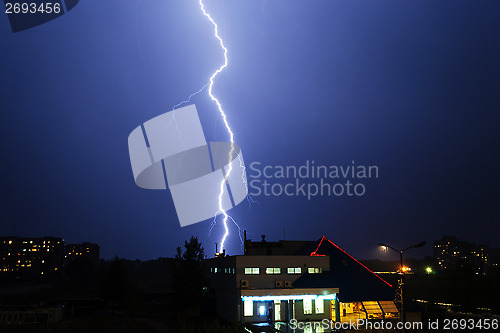 Image of Severe lightning storm over a city buildings
