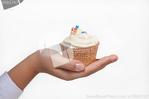 Image of hand holding a cupcake isolated on white
