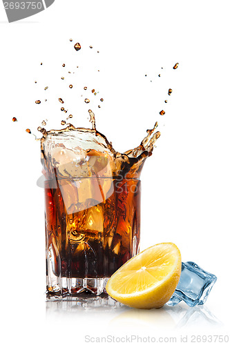 Image of splash of cola in glass with lemon and ice isolated on white