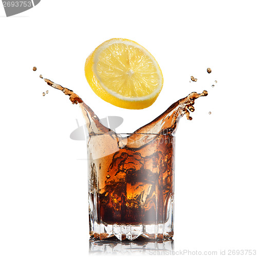 Image of splash of cola in glass with lemon isolated on white