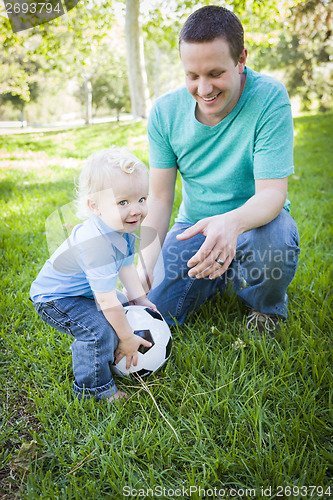 Image of Young Boy and Dad Playing with Soccer Ball in Park