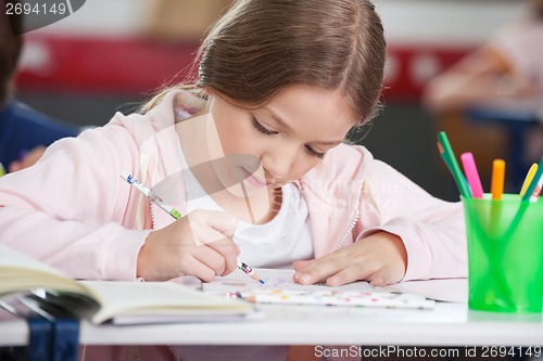 Image of Schoolgirl Drawing At Desk